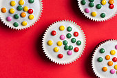 Cacao sweet muffins with white chocolate and colorful bonbons