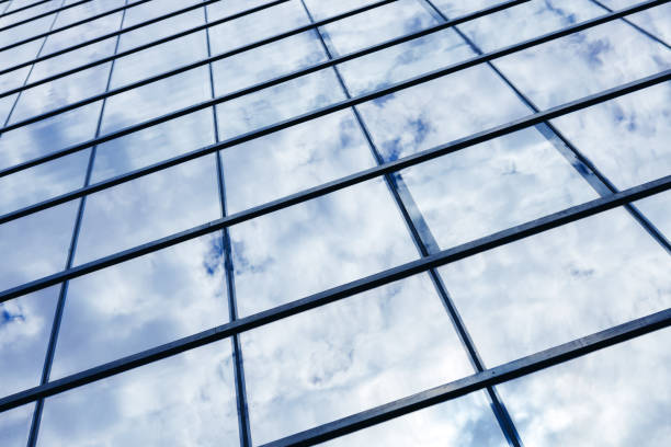 istock Glass skyscraper building with cloudy blue sky background 1330670073