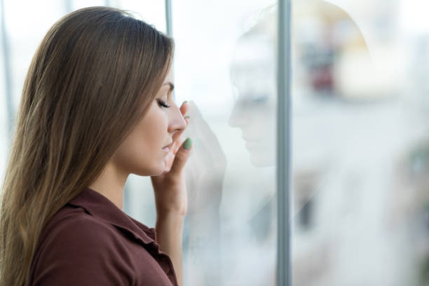 istock Sad woman near window 1330673556