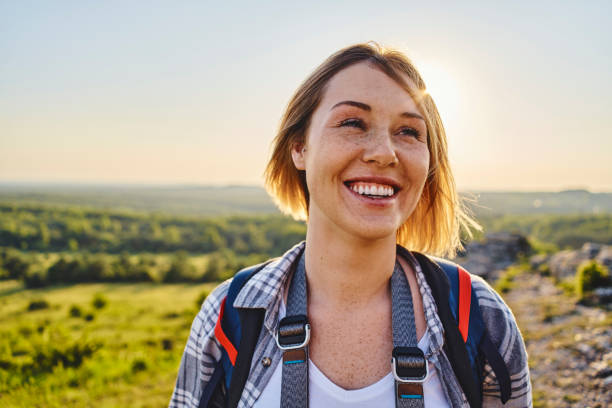 Portrait of a smiling woman hiking with backpack during summer holiday stock photo