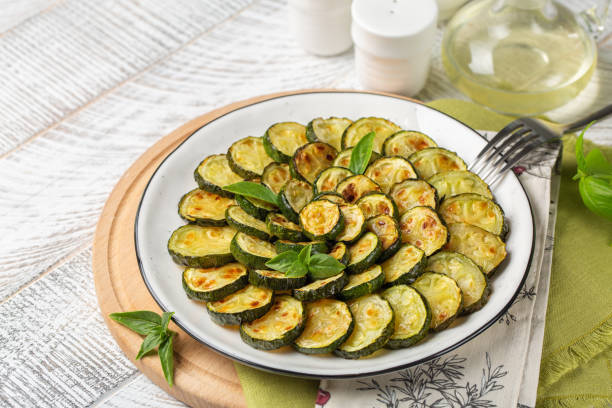 istock Homemade roasted young zucchini. Wooden white surface, copy space. 1330675409