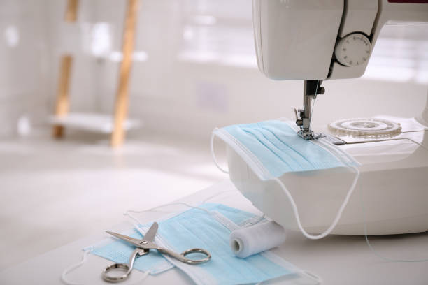 istock Sewing machine with disposable face mask on table indoors, space for text 1330675510