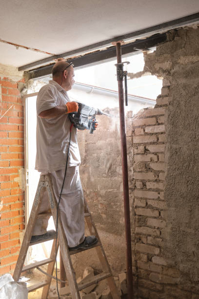 istock Mason breaking a house wall with a demolition hammer. 1330681286