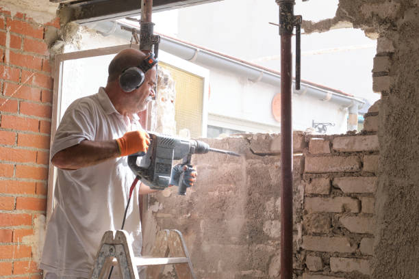 istock Mason breaking a house wall with a demolition hammer. 1330681335