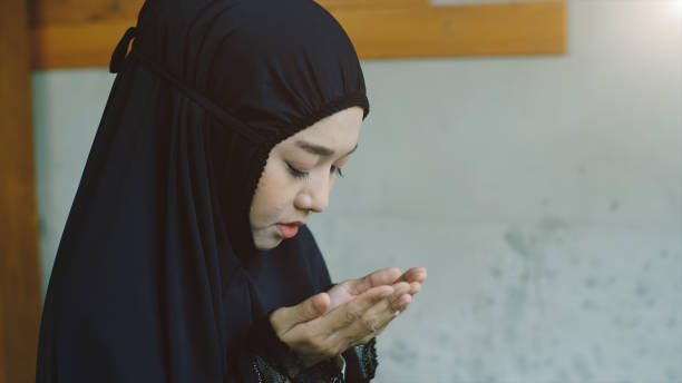 Asian Muslim Woman Praying and Prostrating at Home stock photo