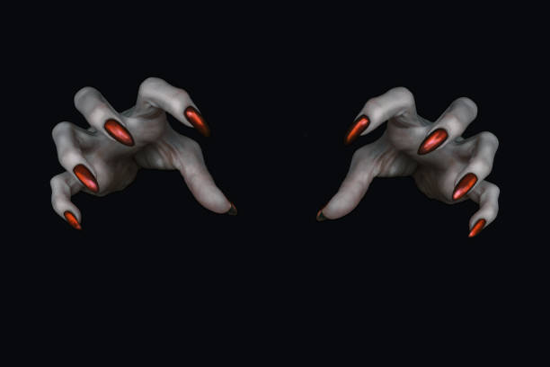 Scary deathly pale knobby fingers with sharp red nails in the dark. Witch hands put a spell, low key, selected focus. Halloween, Samhain, hex, witchcraft, danger, demon, evil, creepy and monster concept.