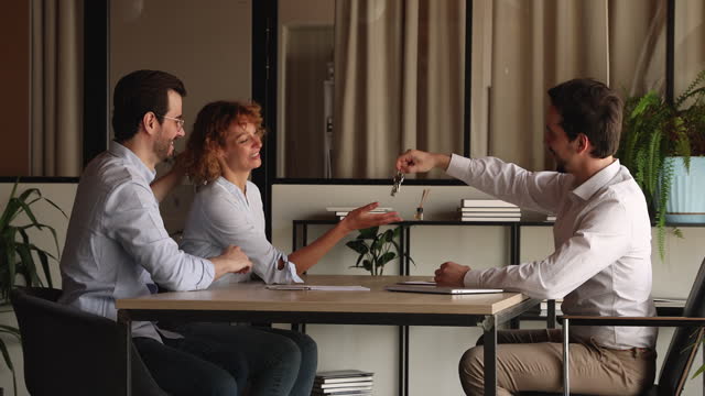 Couple sign contract shake hands Real Estate Agent getting keys from house