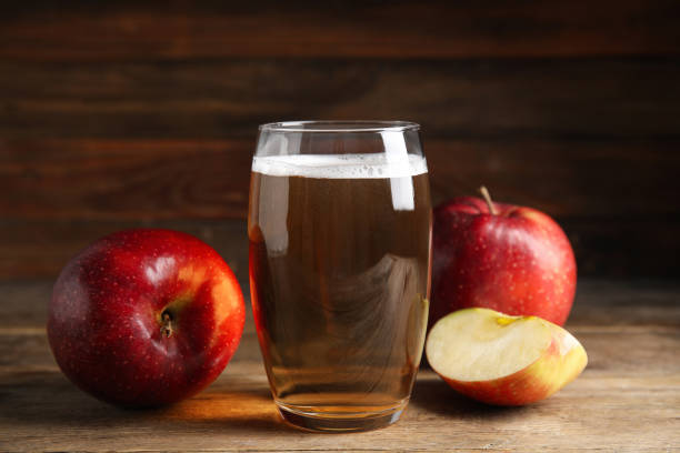 glass of delicious cider and ripe red apples on wooden table - hard drink imagens e fotografias de stock