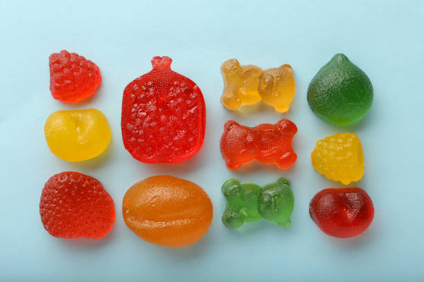 istock Mix of different delicious gummy candies on light blue background, flat lay 1330686643
