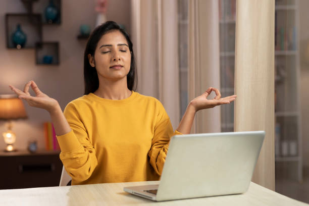 istock Young woman meditating practicing yoga while working at home 1330688054