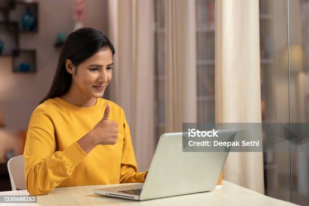 Shot Of A Young Women Using Laptop At Home Stock Photo - Download Image Now - Video Conference, India, Thumbs Up