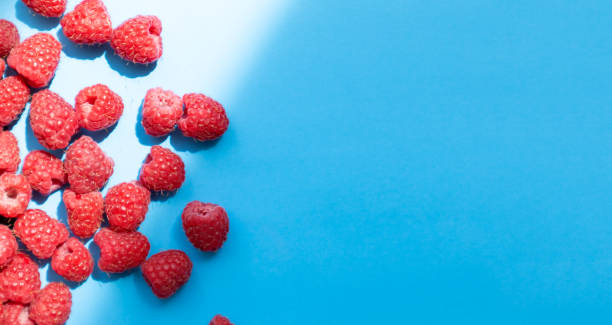 istock Fresh and sweet raspberry in a blue background. Top view 1330689536