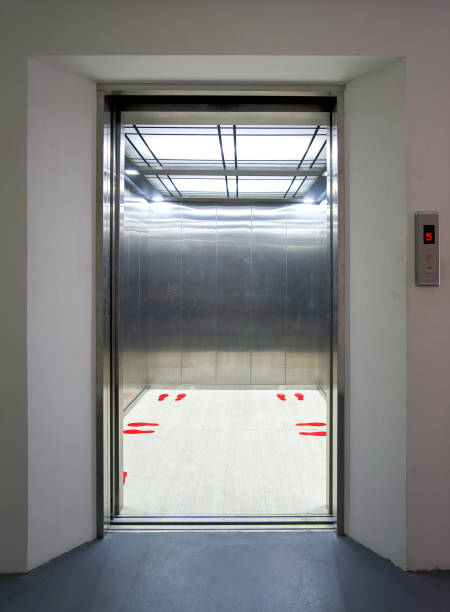 istock Office building elevator entrance. Red footprint symbol inside the elevator show standing position and distance of each person. Social distancing to reduce the spread of infectious diseases Covid-19. 1330692618