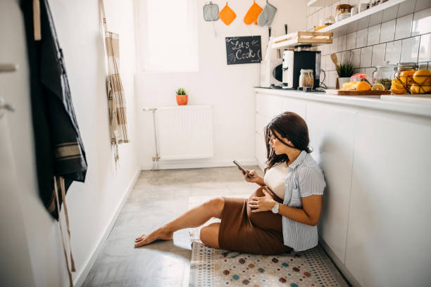 istock Young pregnant woman using mobile phone 1330693124