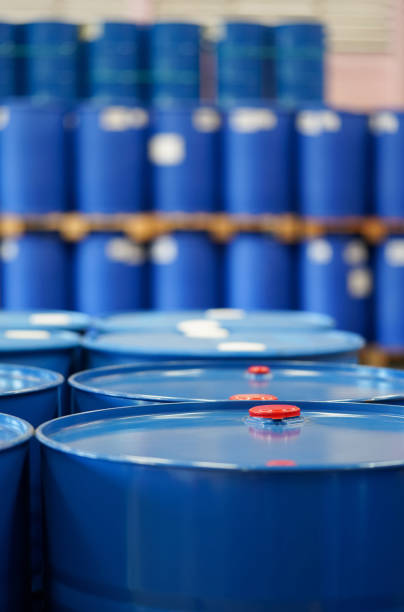 tappo rosso su botti chimiche blu.  molti barili si allineano sullo sfondo. - oil distribution foto e immagini stock
