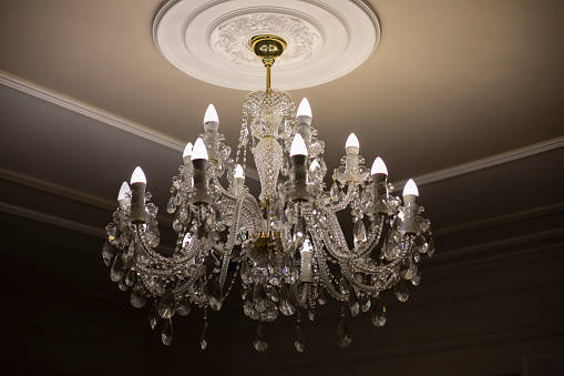 Glass chandelier. Ceiling light source. Lamps shine through a vintage chandelier.