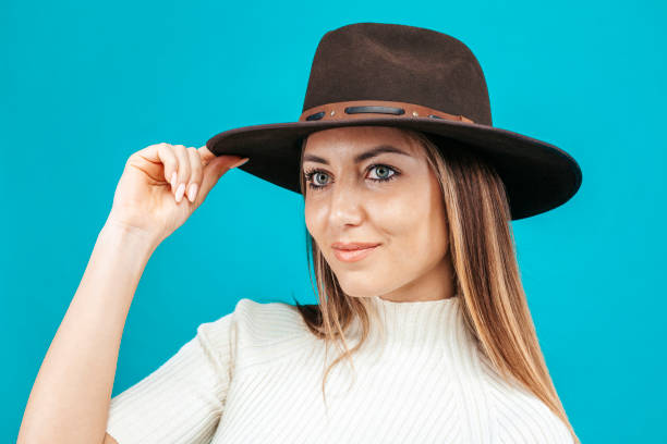 Close up fashion portrait of young beautiful woman wearing a cowboy hat posing at studio