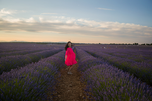 young happy and beautiful Asian Korean woman in Summer dress enjoying nature running free and playful outdoors at purple lavender flowers field in romantic beauty concept