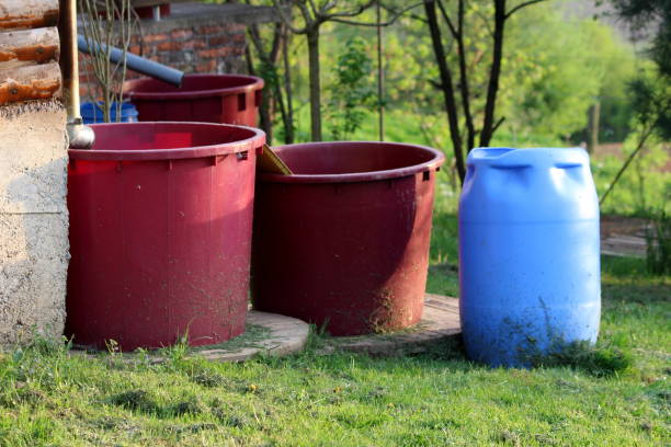istock Various size shape and colors plastic barrels used for storing rainwater to be used with garden drip irrigation system 1330697832