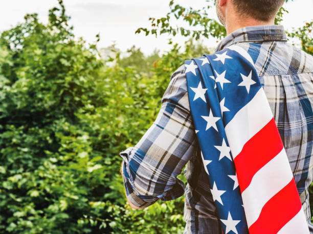 istock Handsome man holding US flag in his hands 1330701588