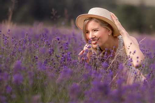 The summer season.Lavender fields. A girl in a straw hat in a field of lavender .