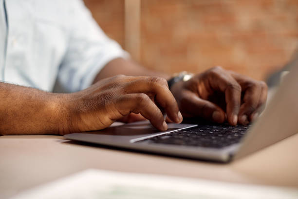 istock Close-up of black businessman typing on a computer while working in the office. 1330704044