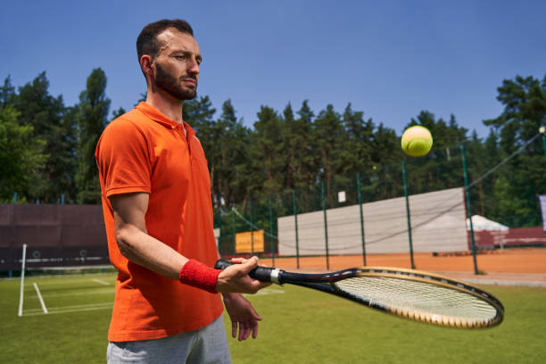 istock Concentrated mustached bearded athlete bouncing the ball on the racquet 1330704325