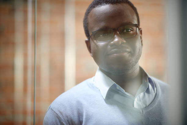 istock Smiling black businessman contemplating while working in the office. 1330704424