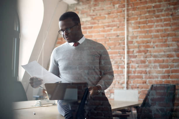 istock African American businessman analyzing reports and working on laptop in the office. 1330704650