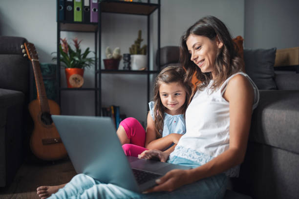 istock Mother and dwaugter having fun watching caroons on laptop 1330704659
