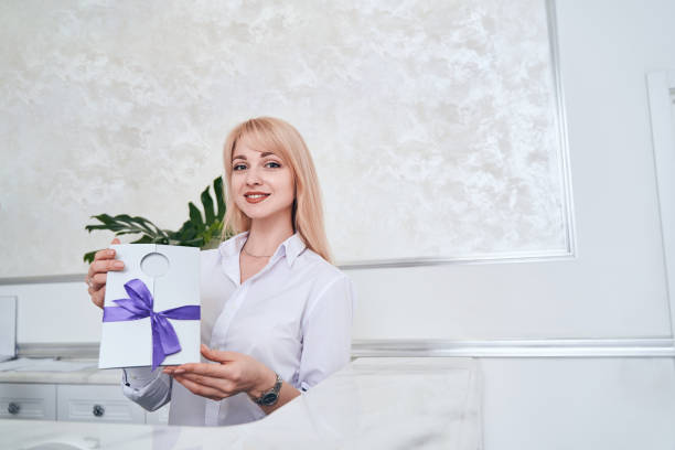 istock Delighted administrator demonstrating gift card for sale 1330710081