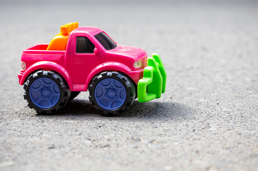 Pink toy truck car on the asphalt ground. Off road car.