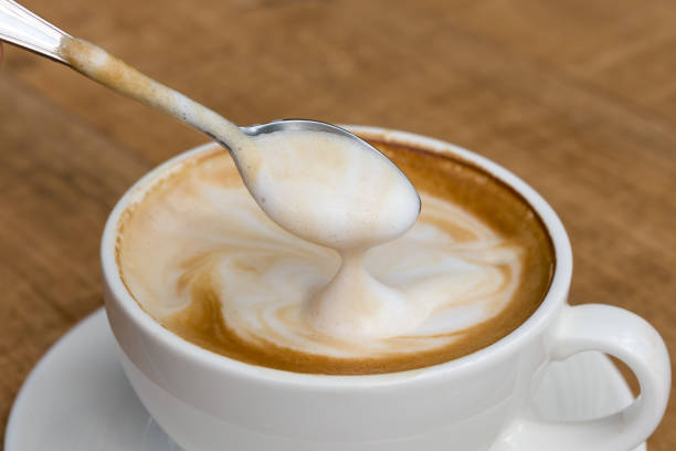 Latte coffee on wooden table Latte coffee in white coffee cup with plate and spoon on white background, Closeup cappuccino stock pictures, royalty-free photos & images