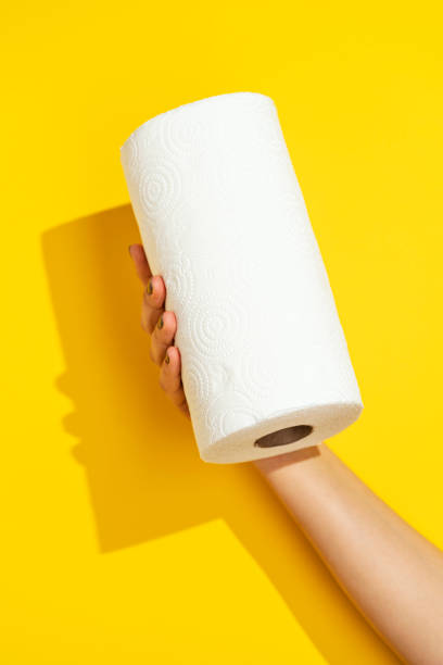 Hand holding paper towel roll Hand holding paper towel roll on yellow background paper towel photos stock pictures, royalty-free photos & images