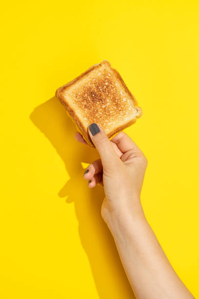 istock Hand holding toast on yellow background 1330714671