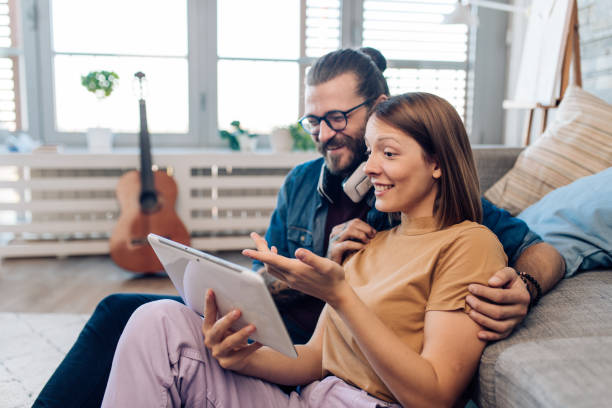 istock Young couple using tablet at home and having fun 1330720463