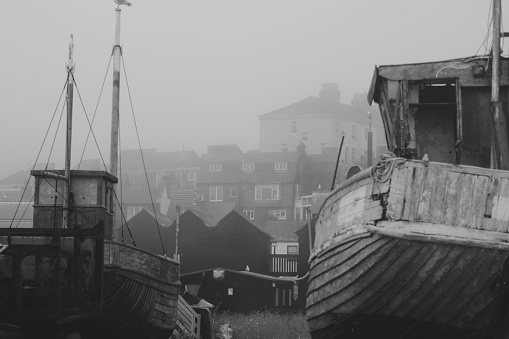 A foggy, misty day at The Stade Hastings and local fishing boats have been hauled onto the shingle beach until the next high tide. The sea mist creates a mysterious, atmospheric looking landscape