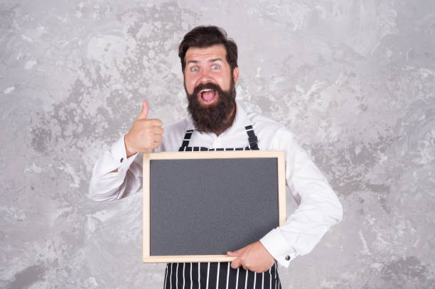 istock Man good looking hospitable restaurant waiter with blackboard copy space, perfect quality concept 1330725693