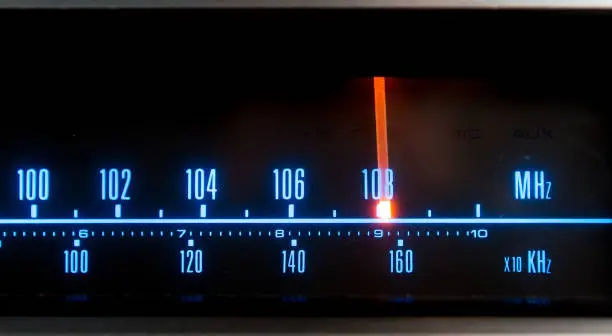 Classic radio tuner panel close-up. Black background