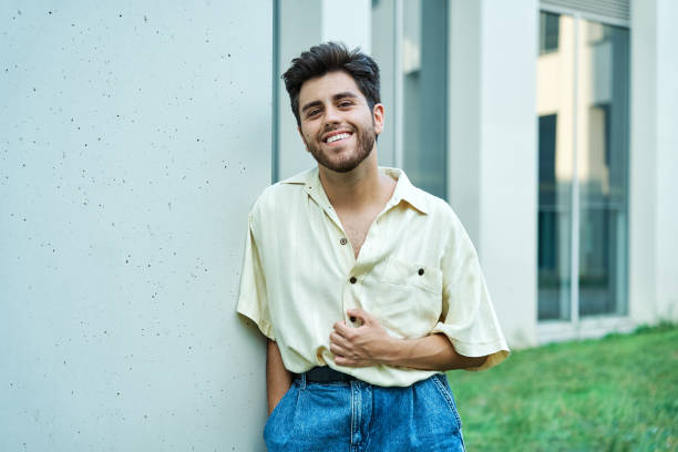 istock man with beard smiling. Dressed in jeans and yellow shirt 1330726604