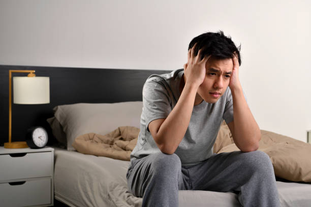 istock Depressed young Asian man sitting in bed cannot sleep from insomnia 1330727666