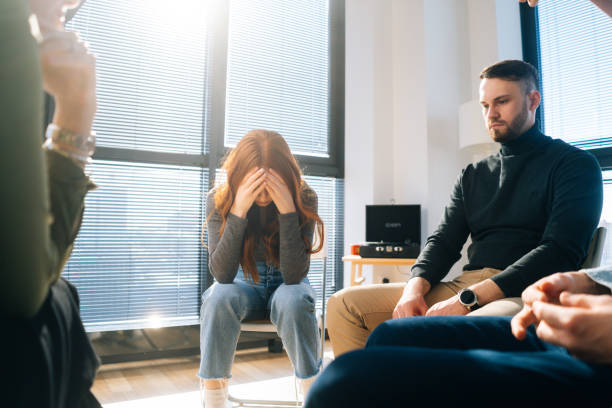 istock Front view of sad crying young woman sharing problem sitting in circle during group therapy session. 1330728502