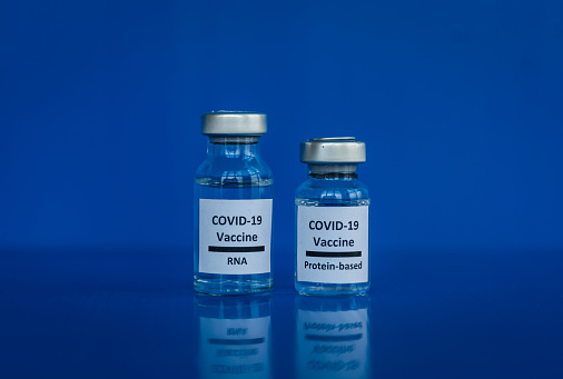 Vacunas contra el ARNm y las proteínas contra la COVID-19 con fondo azul photo