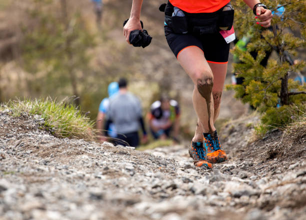 istock Female athlete legs covered by mud during mountain run race 1330730667