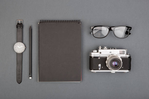 istock Journalist or blogger table - spiral blank notebook, pencil, camera and glasses on gray background, top view 1330731234