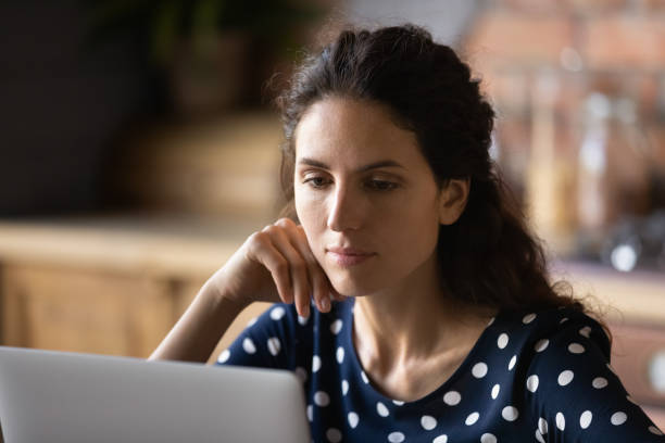 istock Focused adult student woman using laptop in kitchen 1330731589
