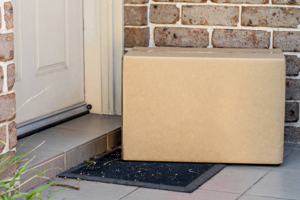 Parcel box delivered to a front door of residential building Parcel box delivered to a front door of residential building. Online shopping and delivery. Post shipping doorstep stock pictures, royalty-free photos & images