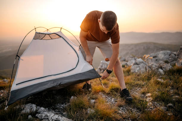 istock Mature man installing tent on hiking 1330734050