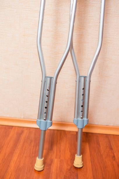istock Pair of Crutches for Disabled People Placed Against Wall Indoors. Vertical Image Composition 1330734305
