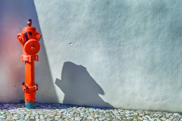 Closeup View of Old Styled Red Fire Cock Hydrant Against of Wall Located On One of The Streets in Portugal. Horizontal Shot